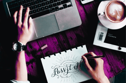 an aerial view of a graphic designer sketching a design with a laptop, mobile and coffee